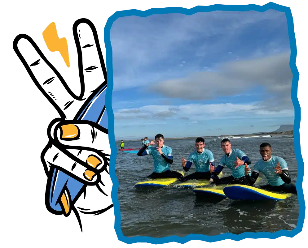 Four people in blue shirts sit on surfboards in the sea, smiling and making hand signs during Surf Lessons Strandhill Sligo. The background shows a cloudy sky and distant surfers, with a cartoon hand holding a lightning bolt on the left side.